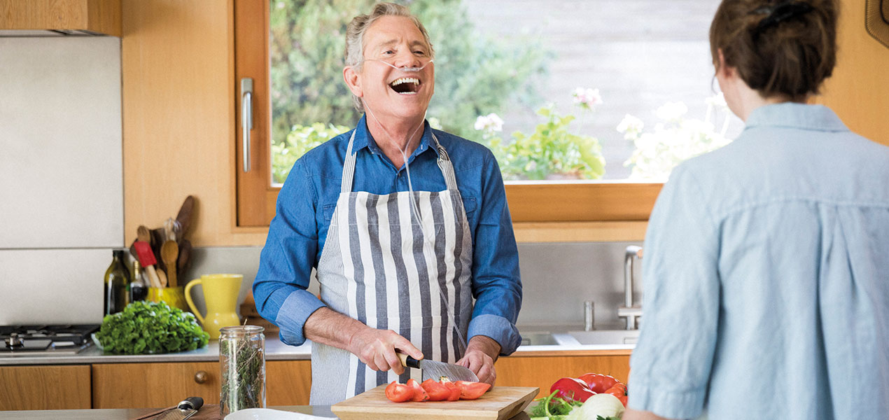 Mann mit Atemmaske beim Kochen