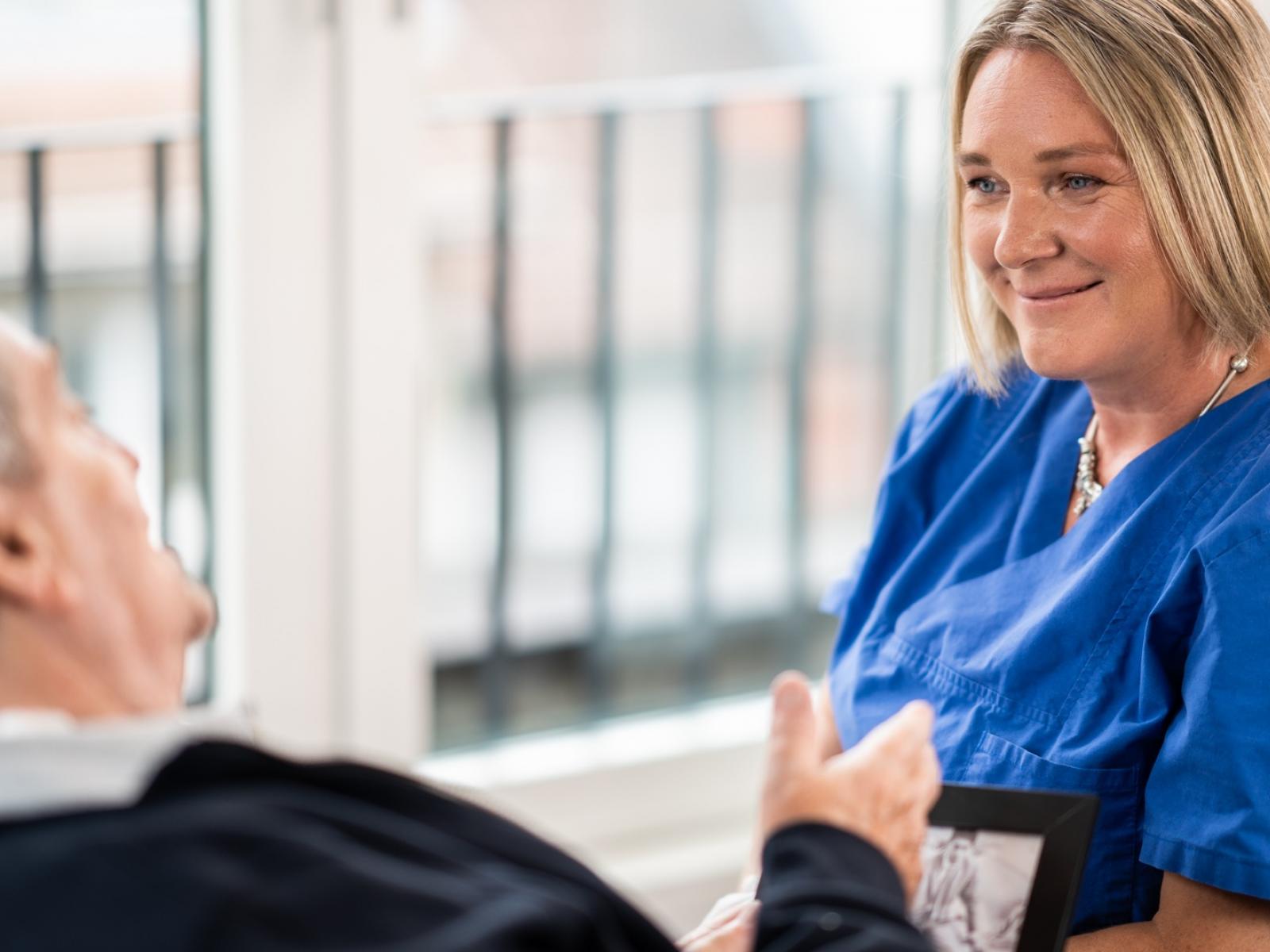 Pflegefachkraft im Gespräch mit einem Patient